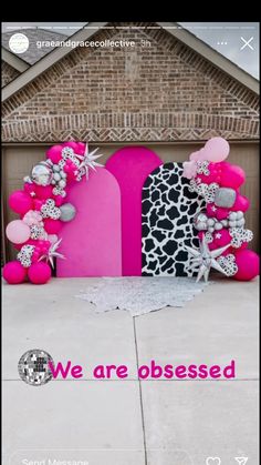 a pink and black sign sitting on top of a cement ground next to a building