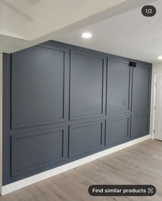 an empty room with gray walls and wood floors