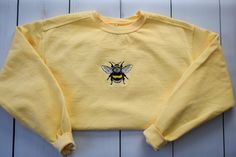 Embroidered Bumble Bee Sweatshirt ✳ The photo samples show this sweatshirt in the color: butter. ✳ SIZING - Please review the size chart to select the best fit. All sweatshirts are unisex. ✳ FEATURES classic fit air jet yarn for softer feel and reduced pilling double-needle stitching at shoulders, armholes, neck, waistband and cuffs 1x1 rib with spandex for enhanced stretch and recovery ✳ MATERIALS preshrunk cotton/polyester ✳ REFUNDS / RETURNS / EXCHANGES - All items are made to order and not e Cute Yellow Crew Neck Sweatshirt, Bee Sweatshirt, Bee Sweater, Hot Pink Sweatshirt, Cottagecore Sweater, Embroidered Bee, Blue Shirt With Jeans, Cottagecore Clothes, Bee Embroidery