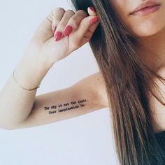 a woman with long hair has a tattoo on her arm that reads, the only is not the line your connection to