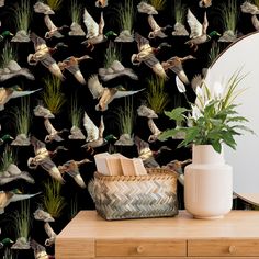 a wallpaper with birds flying over the grass and flowers in front of a mirror