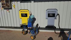 a person pushing a cart with two mailboxes on the side of a building