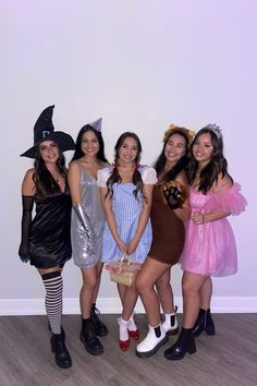 four girls dressed up in costumes posing for the camera