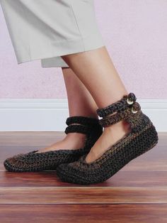 a woman's feet wearing black crochet shoes