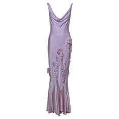 This John Galliano bias-cut satin gown in soft lavender features a draped cowl neckline and an open back. Satin ribbon appliqués run along the skirt, adorned with bows for added detail. The bias cut allows the fabric to fall fluidly, accentuating the body, while the flared hem creates movement. ▪ Brand: John Galliano ▪ Creative Director: John Galliano ▪ Collection: Spring-Summer 2004 ▪ Fabric: Crepe-Backed Satin ▪ Size: FR40 - UK12 - US6 ▪ Made in: France ▪ Condition: Very Good ▪ Mannequin: 183 John Galliano Wedding Dress, John Galliano Dress, Dream Wishlist, Dress With Ribbon, Bias Cut Dress, Soft Lavender, Cut Dress, Shopping Photography, Satin Gown