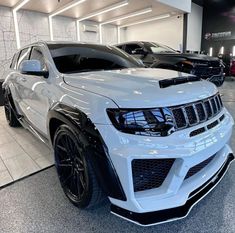 a white jeep is parked in a showroom