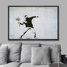 a living room with a couch, table and painting on the wall above it that has a tennis player holding a racquet in his hand