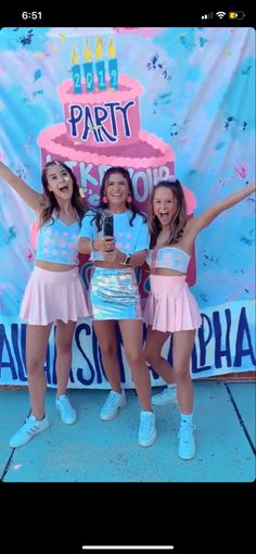 three girls are posing in front of a birthday cake