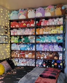 a room filled with lots of stuffed animals next to a wall full of bookshelves