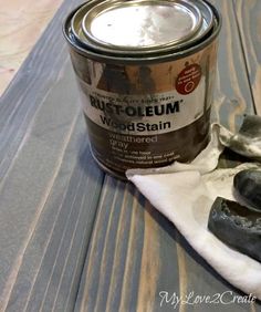 a can of rust - oleeum wood stain next to some rocks on a table