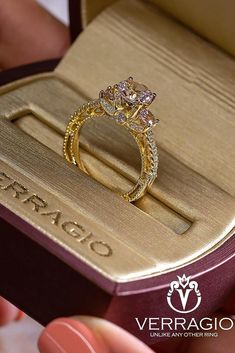 a close up of a person holding a ring in a box with the words veragio written on it