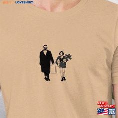 a man and woman walking down the street with bags on their backs t - shirt