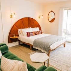 a bedroom with a large bed and green couches