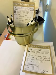 there is a receipt in a bucket on the counter next to a pen and paper