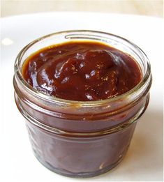 a jar filled with sauce sitting on top of a white plate