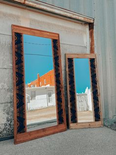 two mirrors sitting next to each other in front of a building with an orange roof