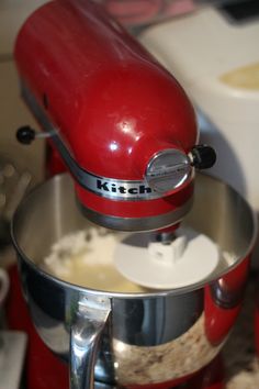 a red kitchen aid mixer sitting on top of a counter