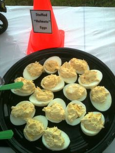 an egg tray with deviled eggs on it sitting on a table next to a traffic cone