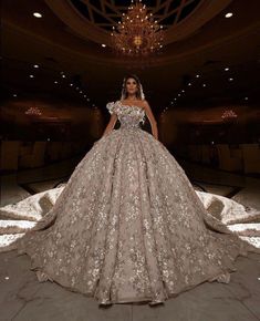 a woman in a ball gown standing on the floor