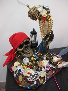 a table topped with a skull wearing a red hat next to a knife and other items