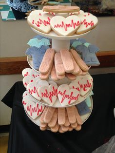 a three tiered tray with heart shaped cookies and slippers on it, all decorated in the same colors