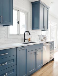 a kitchen with blue cabinets and wood floors