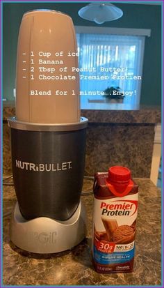 a blender sitting on top of a counter next to a bottle of nut butter