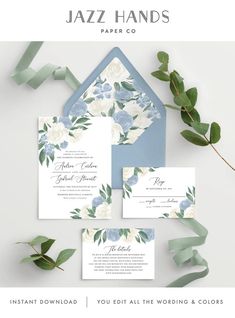 wedding stationery with blue and white flowers, greenery and leaves on the side