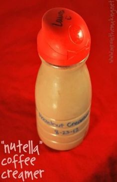 an orange and white baby bottle sitting on top of a red blanket with the words nutella coffee creamer