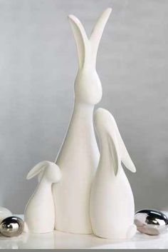 two white ceramic rabbits sitting next to each other