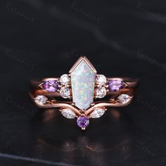 an opal and amethorate ring on a black surface with white diamonds