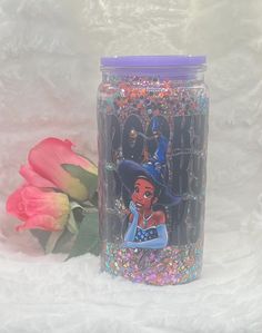 a glass jar with an image of princess and the frog on it next to flowers