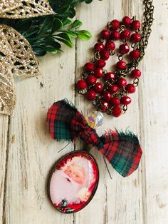 Vintage Santa charm necklace/Christmas jewelry/Santa necklace/Santa necklace/ Santa pendant/red beaded Santa charm necklace/Christmas jewelry Vintage Santa pendant charm necklace,with Czech glass and hand beaded glass ruby red crystal chain!Ab clear fire polished czech glass and vintage Christmas plaid bow.Super cute and ready to sell! Buy it for yourself or gift it for many years of wears and memories!Necklace is 30' long with 15' pearl chain and 15' of bronze chain and 3.5'' pendant drop .  Re Christmas Plaid, Memorial Necklace, Plaid Bow, Vintage Santa, Crystal Chain, Red Crystals, Red Bead, Christmas Jewelry, Plaid Christmas