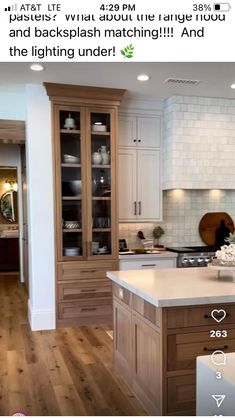 a kitchen with white cabinets and wooden floors is shown on the appliance screen