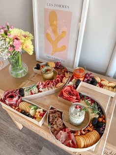 an assortment of appetizers are arranged on a tray with flowers in a vase