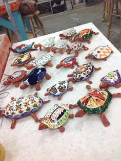 a table topped with lots of colorfully decorated cookies on top of a white counter