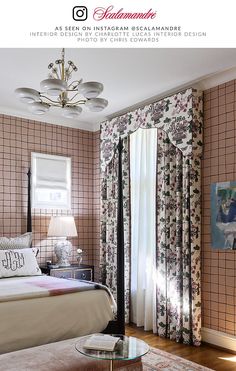 a bed sitting in a bedroom next to a window with curtains on the windowsill