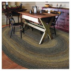 a table and chairs in a room with a rug on the floor next to it