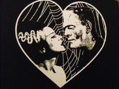 a man and woman kissing in front of a heart with the word love written on it