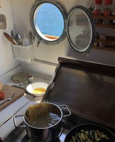 there is a pot on the stove with some food in front of it and an open window