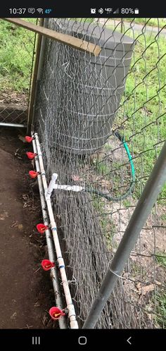 an image of a fence that has some red cups on the ground in front of it