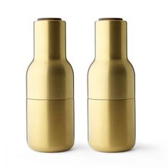 two gold salt and pepper shakers sitting next to each other