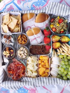 a tray filled with lots of different types of food on top of a table cloth