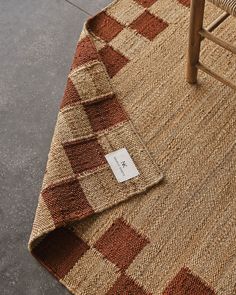 a brown and white checkered rug sitting on top of a wooden chair