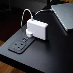 an electronic device is plugged into the charger on top of a black table