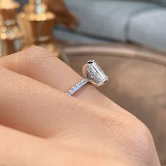 a woman's hand holding a diamond engagement ring