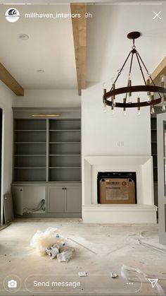 an empty living room with no furniture in it and a chandelier hanging from the ceiling