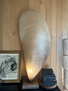 a lamp sitting on top of a wooden table next to a painting and other items