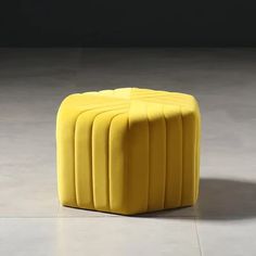 a yellow stool sitting on top of a white floor