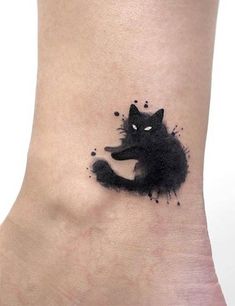 a black cat tattoo on the side of a woman's leg with watercolor drops